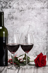 rose flower and two red wine glasses