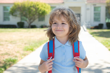 Happy school kid is going to school for the first time. Child boy with bag go to elementary school. Child of primary school. Pupil go study with backpack.