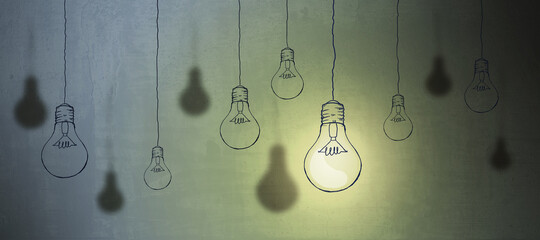 Abstract light bulb sketch on concrete wall background. Idea concept.