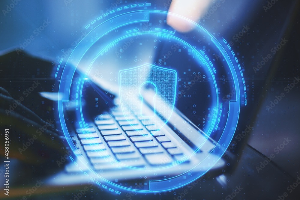 Poster close up of hands using laptop with abstract glowing shield lock on blurry background. antivirus and