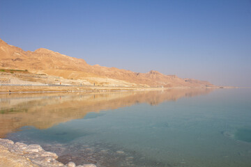 Totes Meer in Israel mit Salzsteinen klarem Waser Spiegelungen und einem Steg