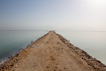 Totes Meer in Israel mit Salzsteinen klarem Waser Spiegelungen und einem Steg