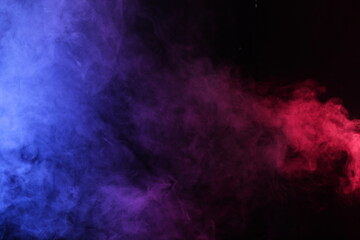 Artifiacial magic smoke in red-blue light on black background
