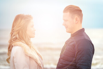 Young couple standing enjoying on a sand and enjoying each other.Summer,spring,autumn vacation.Closeup.Sunset evening.