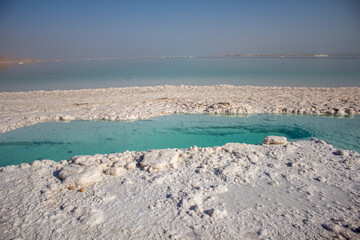 Totes Meer in Israel mit Salzsteinen klarem Waser Spiegelungen und einem Steg