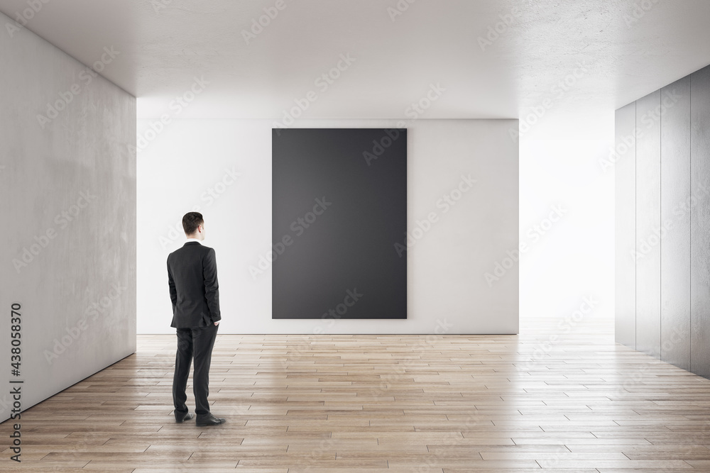 Canvas Prints businessman in modern concrete interior with empty poster looking at mockup place for your advertise