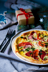 Cooked pizza on aged blue wooden surface background with copy space, side view.