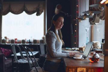 Hands of a woman working on a laptop. A freelance worker completes an order in a cafe.
