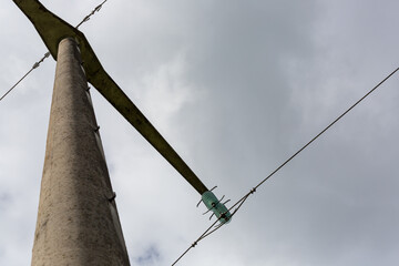 Strommast aus Beton mit Stromleitung und Isolator von unten