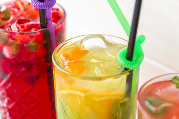 Three different refreshing lemonades on white wooden background