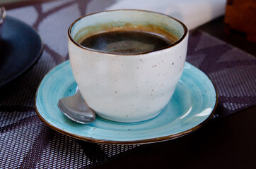 Coffee with foam in a cup is on the table. Coffee house