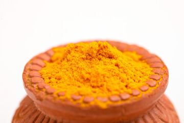 Turmeric powder in clay bowl.