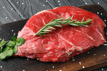 Raw beef fillet piece on wooden board close up