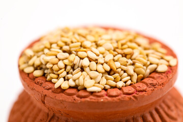 sesame seed in clay bowl over white background.