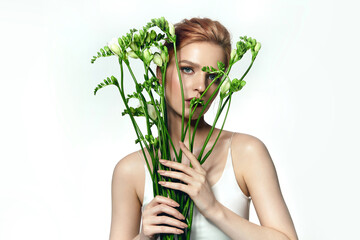 Portrait of a beautiful young woman with red hair and natural makeup. Woman holding a bouquet of white flowers.Advertising natural cosmetics.