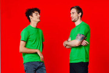 Cheerful friends in green t-shirts hugs communication