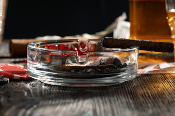 Playing poker with whiskey and cigars on table