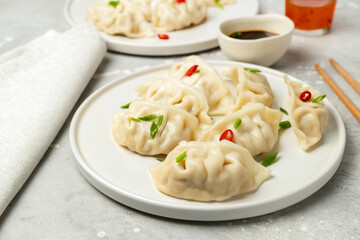 Dumplings Jiaozi Gyoza steamed on white plates with soy sauce and chili sauce. Food Takeout takeaway, home delivery