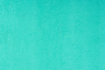 Smooth turquoise concrete wall texture with subtle imperfections, ideal for background use in design or presentations.