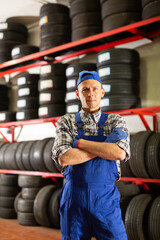 Portrait of mechanic man with auto tires in a tire service