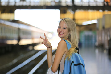 young woman waiting in vintage train, relaxed and carefree at the station platform in Bangkok, Thailand before catching a train. Travel photography. Lifestyle.