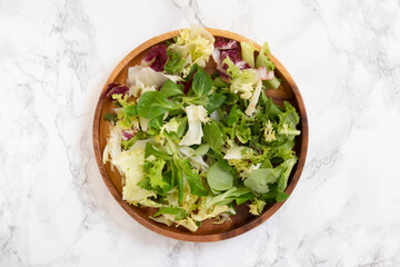 Salad in natural wooden plate