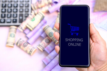 hand holding smartphone with buying and selling services online on network, e-commerce concept, shopping online