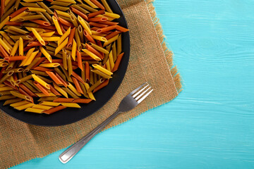 Raw pasta on a black plate, top view, copy space