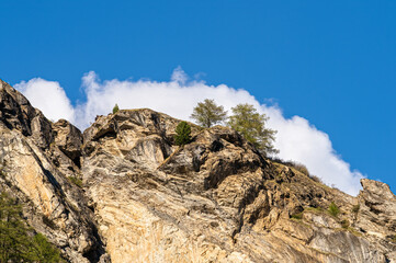 Rocky mountain landscape above Val Herens in Switzerland and a scenic cloud above the top