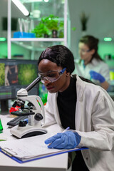 Biochemistry doctor examining chemical test using microscope for genetic researcher. Biologist specialist discovery organic gmo plants while working in microbiology food laboratory.