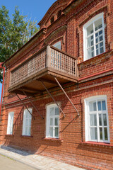 Wooden balcony in an old red brick house