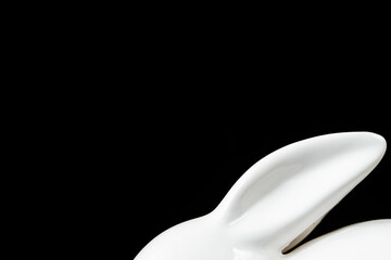 Porcelain toy bunny ears, Easter decoration isolated on black background with copy space.
