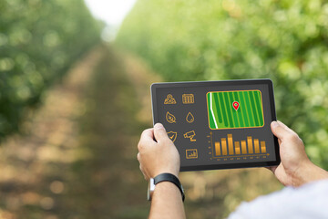 Farmer hands with digital tablet over gadren background