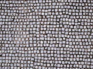 Old cobblestone blocks pavement texture background.