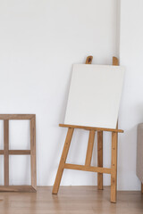 Wooden empty easel in the room interior.