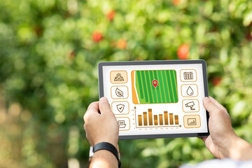 Cropped of farmer standing in garden and using digital tablet