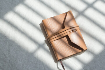 blank brown leather diary on white desk.