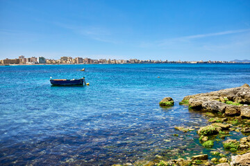 fishing boats moored on the beach with Trapani and the Egadi Islands in front with clear and...