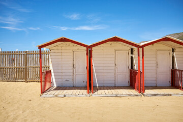 Obraz na płótnie Canvas the wooden cabins mounted with colors for the opening of the summer season on the beach of Sicily