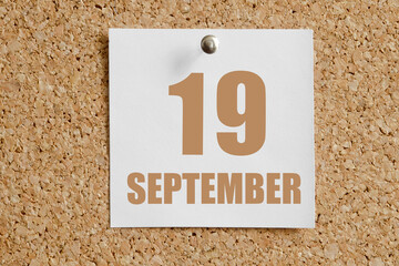 september 19. 19th day of the month, calendar date.White calendar sheet attached to brown cork board.Autumn month, day of the year concept