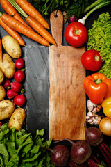 Frame made of fresh ripe assorted vegetables around cutting board