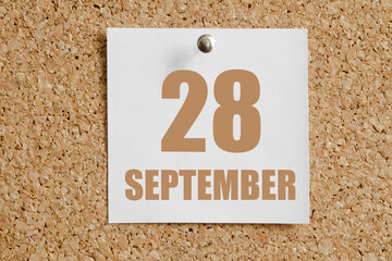 september 28. 28th day of the month, calendar date.White calendar sheet attached to brown cork board.Autumn month, day of the year concept