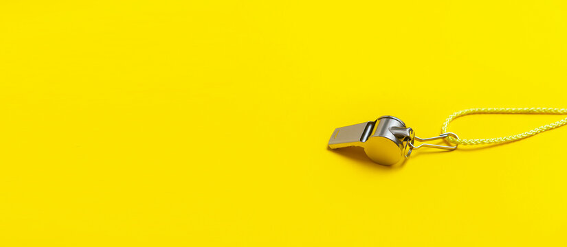 Sports whistle on yellow background. Concept- sport competition, referee, statistics, challenge. Basketball, handball, futsal, volleyball, soccer, baseball, football and hockey referee whistle