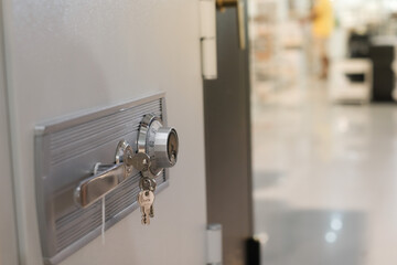Close up of a hand unlocking a safe deposit box by turning a knob with numbers. Composite image between a hand photography 