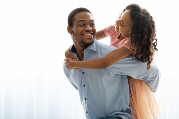 Happy black father and daughter bonding over white background