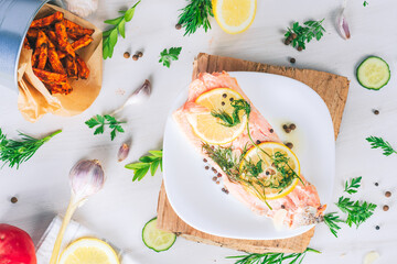 Baked salmon on a bright background. Salmon with vegetable side dishes.
