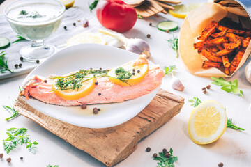 Baked salmon on a bright background. Salmon with vegetable side dishes.
