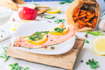 Baked salmon on a bright background. Salmon with vegetable side dishes.
