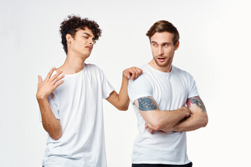 two men in white t-shirts are standing side by side isolated background