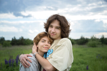 Fototapeta na wymiar Two teenagers in love, a beautiful girl and a guy, outdoors tenderly embrace. carefree day, tenderness of relationships, feelings of love. digital detox, enjoy the moment. vacation, walk for two